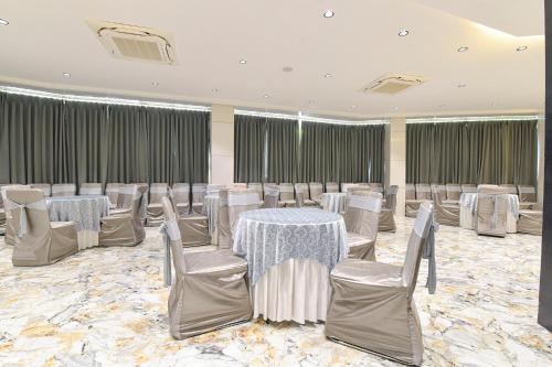 a banquet hall with white tables and chairs at FabHotel Prime The Grey Circle in Indore