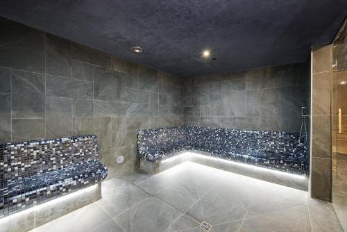a bathroom with a bath tub with blue tiles at Arche Nałęczów & SPA dawne Sanatorium Milicyjne in Nałęczów