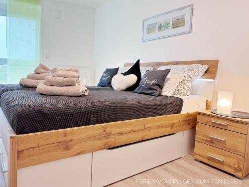 a bedroom with a wooden bed with towels on it at Nordseeklima direkt hinter der Balkontür Ferienwohnung de Twargbutt in Dorum Neufeld