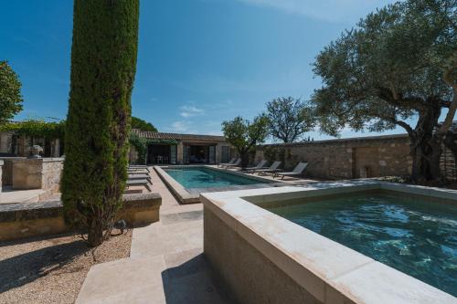 une piscine avec des arbres et une maison dans l'établissement Mas Naste, à Eygalières