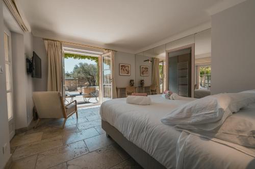 une chambre avec un grand lit et un balcon dans l'établissement Mas Naste, à Eygalières