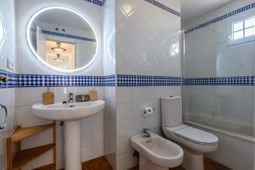 ein Badezimmer mit Waschbecken, Toilette und Spiegel in der Unterkunft Marina IV Atico by Ĥ - Marina Isla Canela PMHIV30P30 in Punta del moral