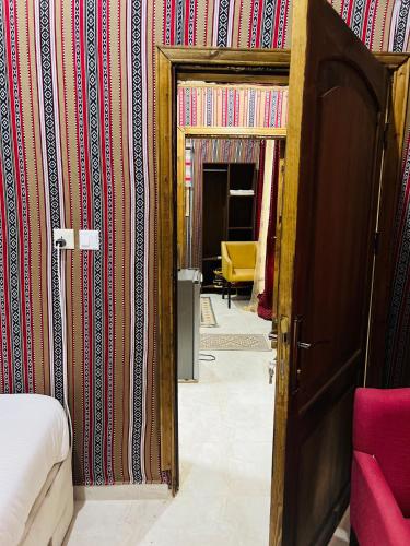 a room with a bed and a hallway with colorful wallpaper at Moon rum 2 in Disah