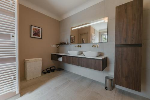 une salle de bain avec deux lavabos et un grand miroir dans l'établissement Mas Naste, à Eygalières