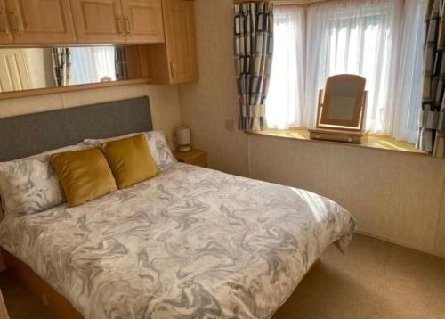 a bedroom with a bed and a tv in a window at Sea View in Port Seton