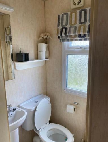 a small bathroom with a toilet and a sink at Sea View in Port Seton