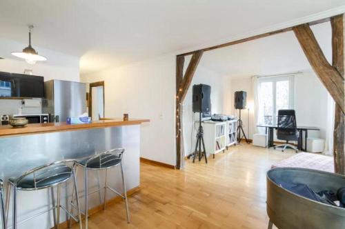 une cuisine et un salon avec un comptoir et des chaises dans l'établissement Appartement Paris Centre Vavin2, à Paris
