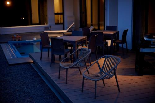 a restaurant with tables and chairs next to a pool at Nanki Shirahama Villa IRIS in Kanayama
