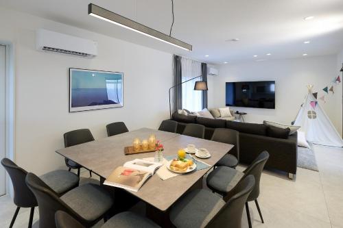 a dining room and living room with a table and chairs at Nanki Shirahama Villa IRIS in Kanayama
