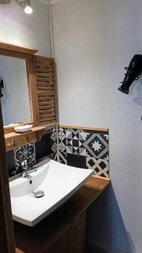 une salle de bain avec un lavabo blanc et un miroir dans l'établissement Chambre avec terrasse - vue jardin, à Pons