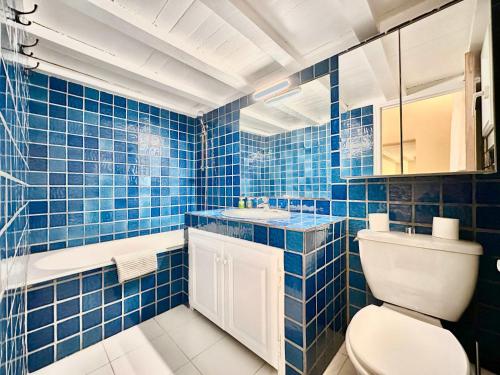 La salle de bains est pourvue de carrelage bleu, de toilettes et d'un lavabo. dans l'établissement Èrsextius, MJD, Aix-en-Provence, à Aix-en-Provence