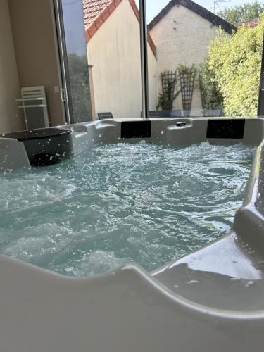 une baignoire jacuzzi remplie d'eau dans une maison dans l'établissement lamaisonCVL à 3km de la mer, à Denneville