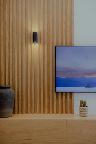 a flat screen tv sitting on a wooden wall at NIAMA Luxury apartments Nafplio in Nafplio