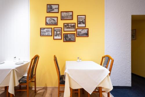 two tables and chairs in a room with yellow walls at Hotel Sonne in Bad Homburg vor der Höhe