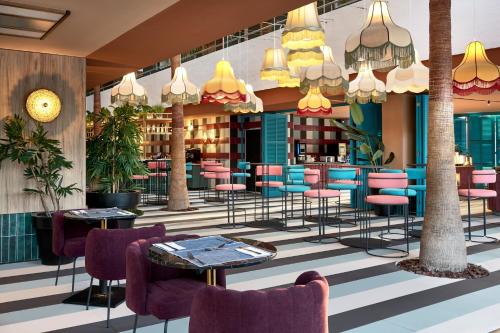 a lobby with tables and chairs in a building at tent Mojito Suites in Magaluf