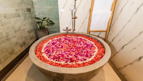 a large tub filled with pink flowers in a bathroom at Maruan Sari in Ubud