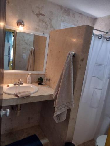 a bathroom with a sink and a shower with a mirror at Beautilful ocean views from this apartment in Chelem