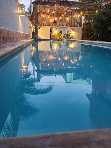 a person standing in a pool with lights in the water at Beautilful ocean views from this apartment in Chelem