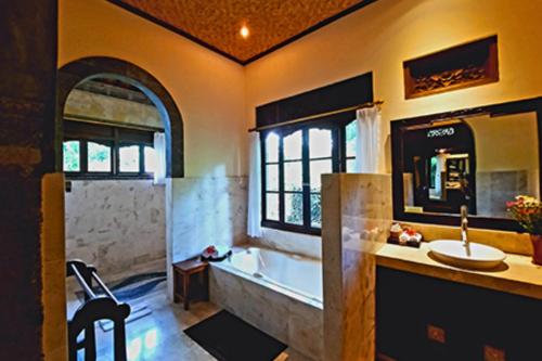 une salle de bains avec baignoire et lavabo dans l'établissement Falguni 1 BR Grand Deluxe Garden View ZN241, à Ubud
