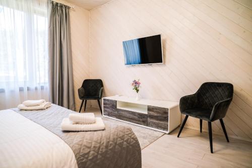 a bedroom with a bed and a desk and two chairs at Oasis Karpat in Polyana