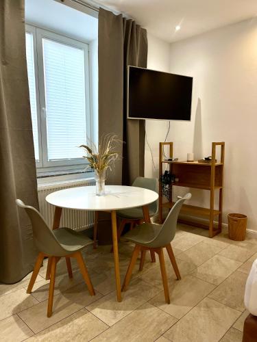 ein Wohnzimmer mit Tisch und Stühlen und einem Fernseher in der Unterkunft Ferienwohnung Dublin in Hannover