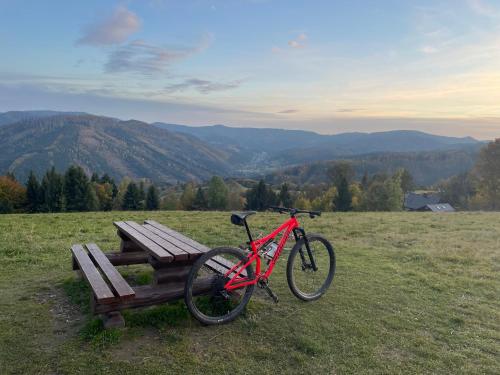 a bike parked next to a bench in a field at Apartmán v Beskydech in Dolní Lomná