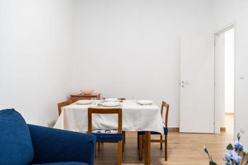 a dining room with a table and a blue couch at The Flower House by Wonderful Italy in Bitritto