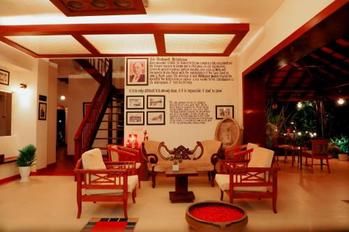 a room with chairs and tables and a wall with a sign at Old Lighthouse Bristow Hotel , Fort Kochi in Cochin