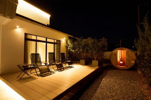 a group of chairs sitting on a deck at night at Nanki Shirahama Villa IRIS in Kanayama