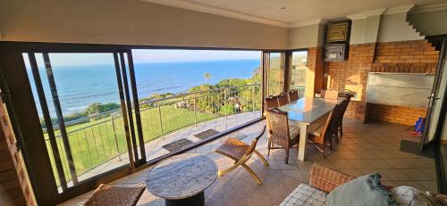 a balcony with a table and chairs and a view of the ocean at Ankervas in Morganʼs Bay