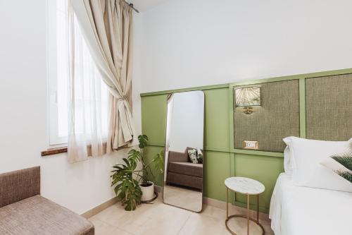 a bedroom with a mirror and a bed and a chair at Boutique Suites 186 in Sorrento