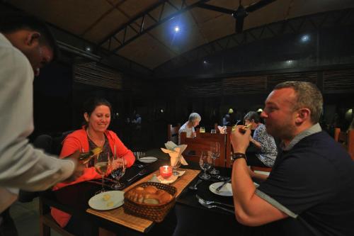 a group of people sitting at a table in a restaurant at The Rainforest Ecolodge - Sinharaja with Shuttle Service from Car Park in Deniyaya