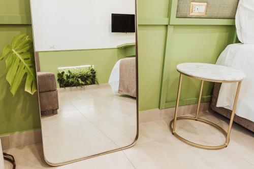 a mirror in a room with a table and a bed at Boutique Suites 186 in Sorrento