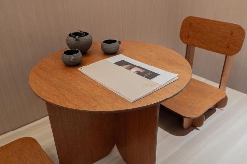 a circular wooden table with vases and a magazine at Jamsil Orosie Tourist Hotel in Seoul