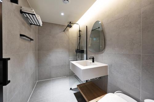 a bathroom with a white sink and a mirror at Jamsil Orosie Tourist Hotel in Seoul