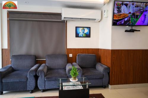 a waiting room with two chairs and a tv at Amar Tree Express in Pātipukur