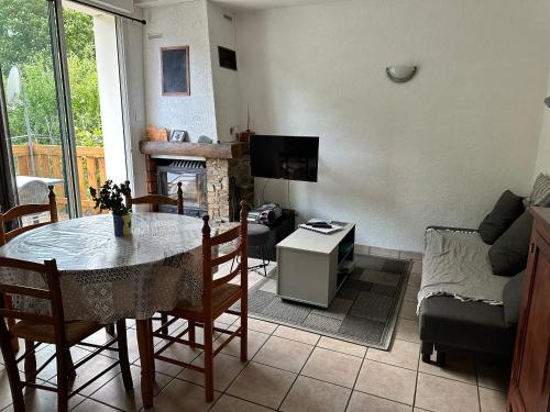 un salon avec une table et un canapé dans l'établissement Appartement rez de jardin calme proche centre ville, à Luchon