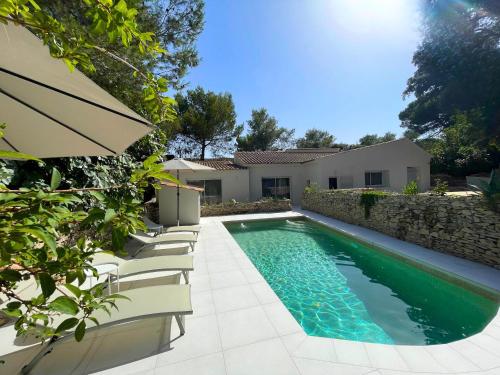 - une piscine avec des chaises à côté d'une maison dans l'établissement Superbe mazet provençal rénové, à Nîmes
