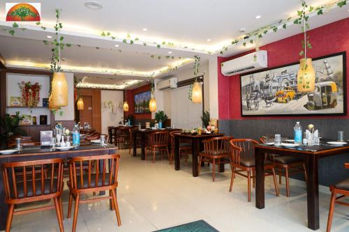 a restaurant with tables and chairs in a room at Amar Tree Express in Pātipukur