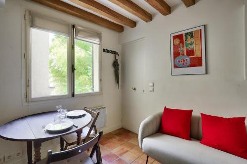 - un salon avec une table, un canapé et une fenêtre dans l'établissement 3min Notre Dame de Paris | Studio, à Paris