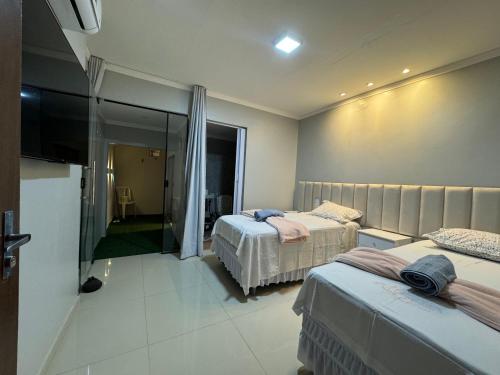 una camera da letto con due letti e una porta scorrevole in vetro di casa charmosa serra da capivara a Coronel José Diaz