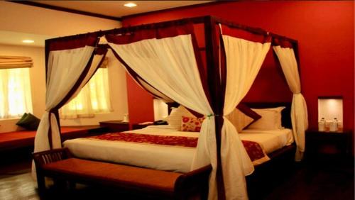 a bedroom with two beds and a canopy bed at Old Lighthouse Bristow Hotel , Fort Kochi in Cochin
