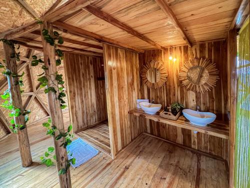 un bagno con due lavandini in un edificio in legno di Kuoom Serengeti a Robanda