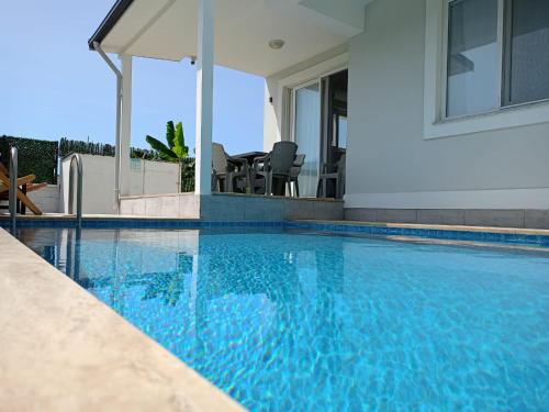 a swimming pool in front of a house at Lavender Villas in Dalaman