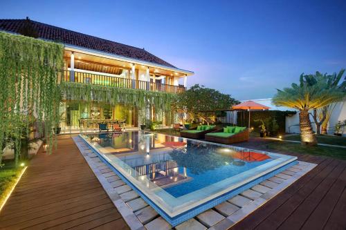a house with a swimming pool in front of a house at ATLAS XXL BEACH BOUTIQUE VILLA Fully Staffed Daily Breakfast Walking Distance to Berawa Beach in Canggu