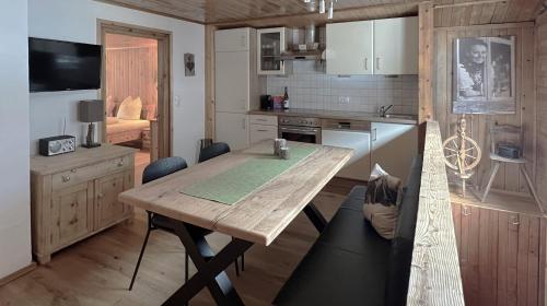 une cuisine avec une table en bois et une salle à manger dans l'établissement Appartements Rudigier, à Gaschurn