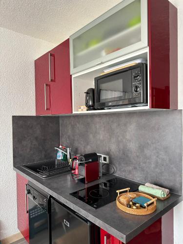 une cuisine avec un comptoir noir avec un micro-ondes dans l'établissement Cet été à Cannes, Studio cosy à 8' de la Croisette, à Cannes