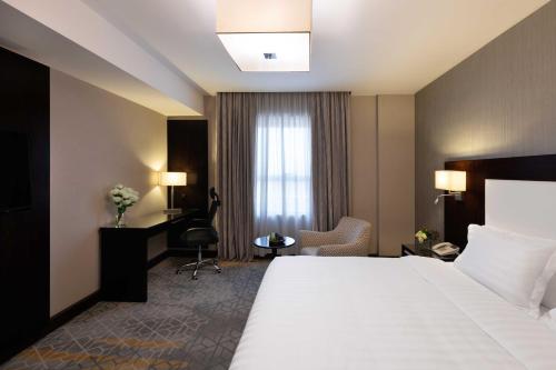 a hotel room with a large bed and a window at Warwick Hotel Jeddah in Jeddah