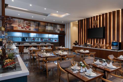 a restaurant with tables and chairs and a bar at Warwick Hotel Jeddah in Jeddah
