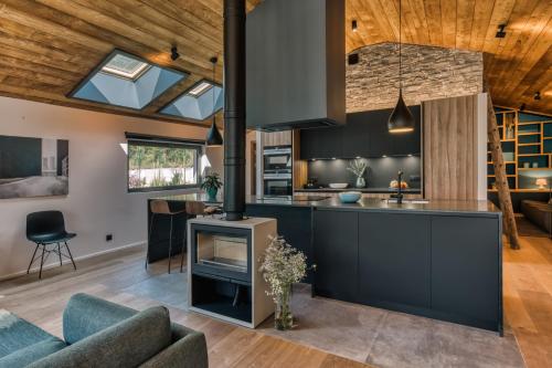 Il comprend une cuisine ouverte et un salon avec un plafond voûté. dans l'établissement Chalet Choucas - Modern Luxury - Heart of Chamonix, à Chamonix-Mont-Blanc